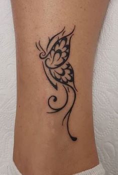 a woman's foot with a butterfly tattoo on her left leg and the word love written in black ink