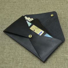 a black wallet sitting on top of a table next to a credit card and money clip