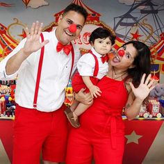 a man and woman with clown noses posing for a photo in front of a carnival theme