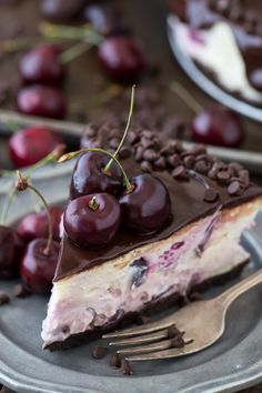 a piece of cheesecake with chocolate and cherries on it