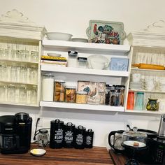 the shelves are filled with many different types of coffee pots and mugs on them