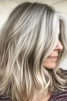 Sandy blonde is a light, muted shade that blends beautifully with gray hair, creating a soft, beachy look. Use a gentle, nourishing shampoo to keep it looking fresh. Click here to check out more where experts and women agree that these colors are perfect or gray hair. Ash Blonde And Gray Hair, Blonde Babylights To Blend Grey, Fall Gray Blonde Hair Color, Blond Grey Hair Going Gray, Blending Greys Into Brown Hair Blonde, Gray And Platinum Hair, Natural Grey Hair With Blonde Highlights, Blonde Highlights Covering Grey, Blond Highlights On Greying Hair