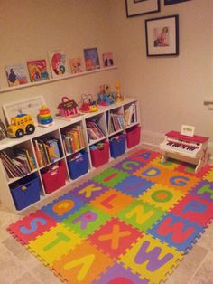 a child's play room with toys and bookshelves on the floor in front of it