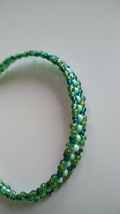 two strands of green glass beads on a white surface