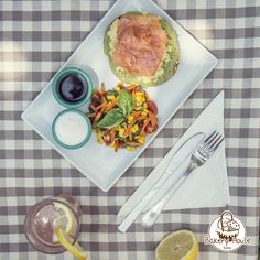 a plate with some food on it sitting on a table next to glasses and silverware