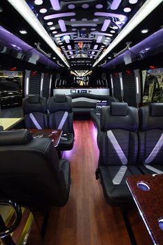 the interior of a bus with black leather seats and wood flooring on both sides