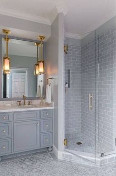 a bathroom with a walk in shower next to a white sink and large mirror on the wall