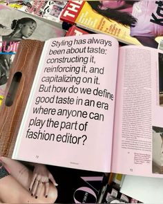 an open book with black and white images on it, surrounded by magazines that include fashion editor