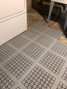 a kitchen floor that has been cut into squares and is next to a washer