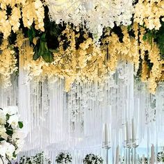 the flowers are hanging down from the ceiling in this wedding ceremony room with chandeliers