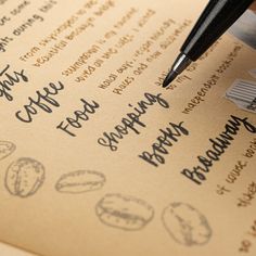 a pen is sitting on top of a menu with food and drinks written in cursive writing