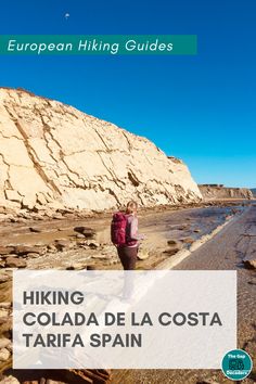 a woman standing on top of a rocky beach next to the ocean with text reading hiking collada de la costa tarifa spain