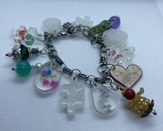 This is a one-of-a-kind handmade charm bracelet.  It features original charms, including ones of resin and shrinky dink.  The entire bracelet is handmade and is the only one of its kind.  Although similar ones can be made, this is truly an original one-of-a-kind masterpiece. The entire bracelet length is 8 inches long and features a lobster claw fastener with some room to make either larger or smaller, depending on wrist size. Priority shipping is free if shipped in the United States. Handmade Clear Bracelets As Gifts, Handmade Clear Bracelets For Gifts, Handmade Clear Bracelets As A Gift, Handmade Clear Beaded Bracelets As Gift, Whimsical Handmade White Charm Bracelet, Whimsical White Handmade Charm Bracelet, Handmade Dangle Charm Bracelet, Whimsical Style, Handmade Dangle Charm Bracelet In Whimsical Style, Handmade Whimsical Charm Bracelet For Friendship