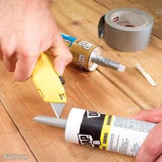 a person is using glue to fix a piece of wood