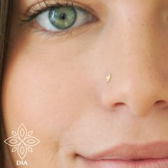 a close up of a woman's face with piercing on her nose