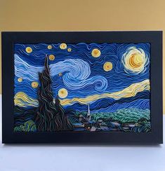 a painting on display in a black frame with yellow and blue swirls around it