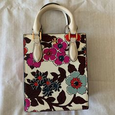 What A Fancy And Beautiful Bag! Cream Color With Floral Print. Saffiano Leather Detachable & Adjustable Shoulder Strap Size: L5.5" X H6.5" Xw2" Tory Burch Emerson, Tory Burch Kira Chevron, Purple Cross, Kira Chevron, Silver Handbag, Tory Burch Purse, Tory Burch Kira, Barrel Bag, Tory Burch Handbags