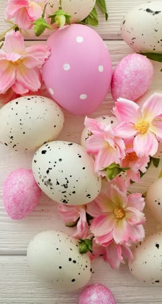 some pink flowers and eggs on a white table