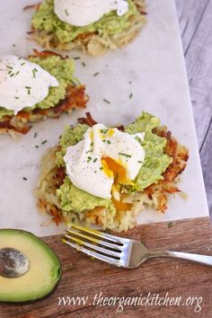 an avocado sandwich with eggs on top and some other toppings next to it