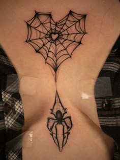 a woman with a spider web tattoo on her back