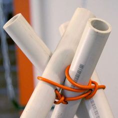 three white pipes with orange cords attached to them