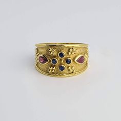 "✔️ The ultimate Byzantine ring collection. This is a wide ring, handmade all in 18K Solid Yellow Gold (750). Detailed with byzantine style granulation  and decorated with precious stones.  ▪️ 2 pear cut Rubies  ▪️ 4 round cut blue Sapphires ✔️ This is a handmade copy from the Greek Byzantine museum. A piece of Art from the Byzantine Period that lasted from the fourth century AD to the 1400s. ➡️  The Byzantine era was a time of riches, so Byzantine jewelry was made with rich metals, like thick gold and silver, and served as a status symbol for those who wore it. The style of Byzantine jewelry is intricately detailed and woven looking designs in thick gold, silver, rose gold, and white gold. Byzantine jewelry can also feature colorful gemstones to make an even brighter and bolder statement Byzantine Clothing Women, Byzantine Style Ring Jewelry, Byzantine Style Gemstone Wedding Ring, Byzantine Style Ring With Intricate Design, Gold Medieval Jewelry, Byzantine Jewelry Ancient, Rubies Jewelry, Gold Byzantine Ruby Ring, Byzantine Ring With Cabochon