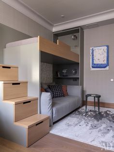 a living room with stairs leading up to the loft bed and storage space under it