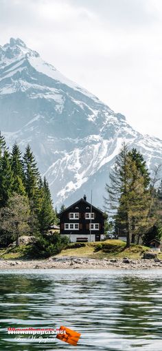 a house on an island with mountains in the background