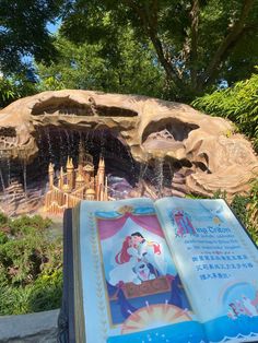 an open book sitting in front of a fountain