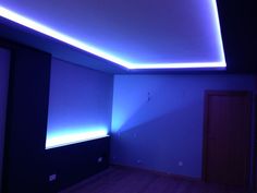 an empty room with wooden floors and blue lighting