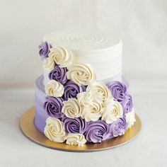 a white and purple cake with flowers on top