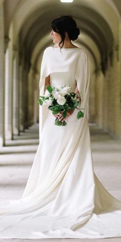 a woman in a white wedding dress holding a bouquet