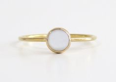 Simple, elegant and classic. This gold pearl ring is made from 14k gold filled material and set with a natural, mother of pearl stone. Each pearl is unique and natural. Whether you're buying this beautiful pearl ring as a gift or for yourself, it will bring forth new beginnings and good luck. Handmade in Los Angeles, CA!  Packaging:  Comes in a gift box, ready for gift-giving! Pearl Size: 5mm Band Size: 1 mm Material:  14k Gold Filled Benefits of 14k gold-filled jewelry: 1. Consists of solid gol Minimalist Oval Yellow Gold Pearl Ring, Gold Pearl Ring With Gemstone, Gold Moonstone Ring In 14k Gold, Gold Pearl Promise Ring With Simple Design, Minimalist Gold Oval Pearl Ring, Minimalist Pearl Ring With Birthstone, Gold Minimalist Oval Pearl Ring, Gold Pearl Birthstone Ring, 14k Gold Round Pearl Ring