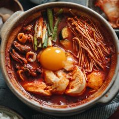 a bowl filled with meat, vegetables and an egg