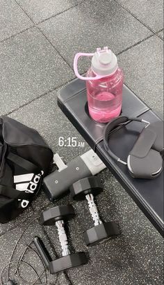 the contents of a gym bag are laid out on the ground next to a water bottle