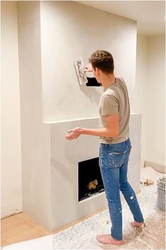 a man standing in front of a white fireplace