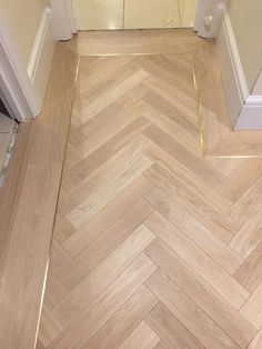 an empty hallway with wood flooring and white trim