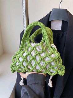 a person holding a green purse on top of a mannequin's head