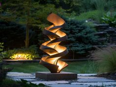 a sculpture in the middle of a garden at night