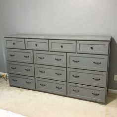 a large gray dresser sitting next to a wall