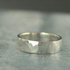 a silver ring sitting on top of a cement floor next to a gray wall,