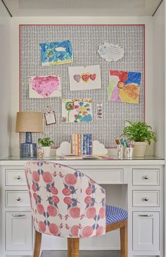 a desk with a chair and pictures on the wall