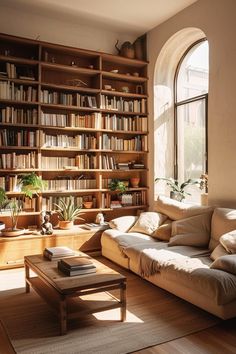 a living room filled with lots of furniture and bookshelves next to a window