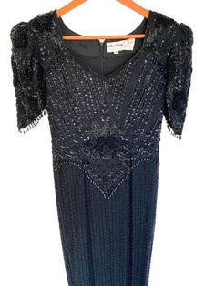 Description: Elevate your wardrobe with this stunning vintage LeMonde Fashions black gown. Featuring exquisite sequin and bead detailing, this dress is perfect for special occasions. In great used condition with minor wear. ✂------ M E A S U R E M E N T S ------- Waist: 16" inches Length: 59 inches Size: 8 Tag/Label: LeMonde Fashions Condition: Great used condition with minor wear. Please review images for details. Black Embellished Sequin Dress For Wedding, Vintage Black Fitted Sequin Dress, Vintage Fitted Black Sequin Dress, Black Fitted Vintage Sequin Dress, Elegant Beaded Fringe Evening Dress For Formal Occasions, Elegant Evening Dress With Beaded Fringe, Elegant Beaded Fringe Evening Dress, Vintage Black Embellished Evening Dress, Vintage Black Sequin Evening Dress