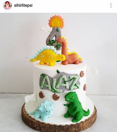 a birthday cake decorated with dinosaurs and letters