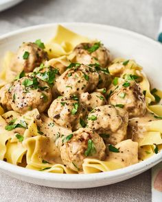 a white bowl filled with pasta and meatballs