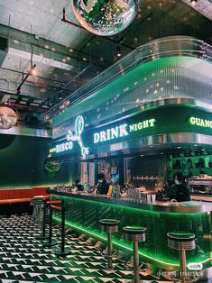 the interior of a restaurant with green lights and black and white checkered flooring