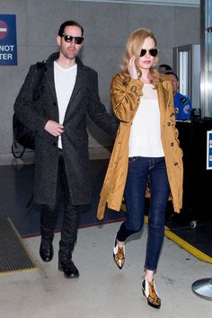 a man and woman walking through an airport