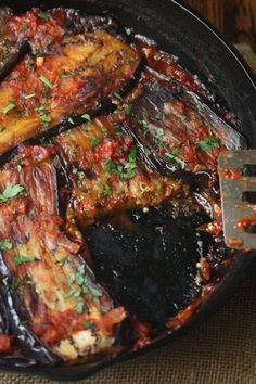 an eggplant dish in a skillet with a fork resting on the side