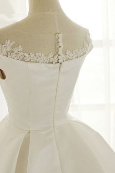 the back of a wedding dress on a mannequin headdress in front of a window